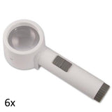 White, round lens stand magnifier with cylindrical handle grey on/off switch and grey battery port. 6x.